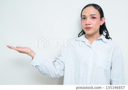 Portrait of a young Thai transgender person presenting something against white background Portrait of a young Thai transgender person presenting something against white background 135146857