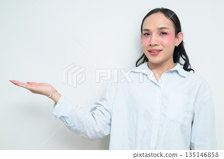 Portrait of a young Thai transgender person presenting something against white background Portrait of a young Thai transgender person presenting something against white background 135146858