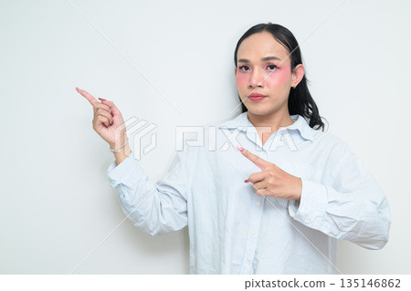 Portrait of a young Thai transgender person pointing finger against white background Portrait of a young Thai transgender person pointing finger against white background 135146862