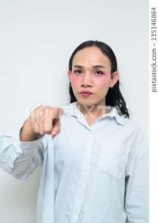 Portrait of a young Thai transgender person pointing finger against white background 135146864