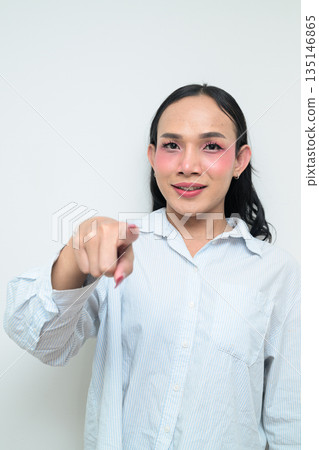 Portrait of a young Thai transgender person pointing finger against white background 135146865