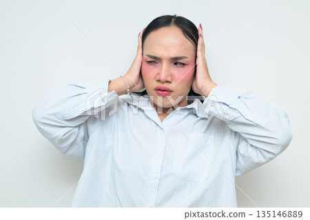 Portrait of a young Thai transgender person covering ears against white background Portrait of a young Thai transgender person covering ears against white background 135146889