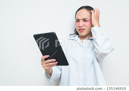 Portrait of a young Thai transgender person using digital tablet computer against white background 135146910