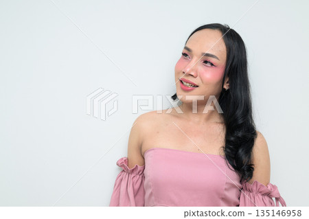Portrait of a young transgender person against white background smiling and looking up thinking Portrait of a young transgender person against white background smiling and looking up thinking 135146958