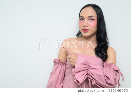 Portrait of a young Thai transgender person against white background pointing finger Portrait of a young Thai transgender person against white background pointing finger 135146973