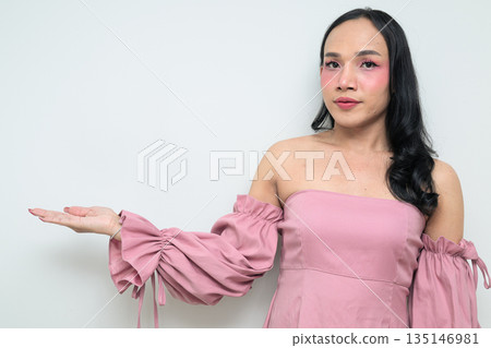 Portrait of young Thai transgender person against white background presenting and showing something Portrait of young Thai transgender person against white background presenting and showing something 135146981