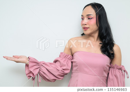 Portrait of young Thai transgender person against white background presenting and showing something Portrait of young Thai transgender person against white background presenting and showing something 135146983