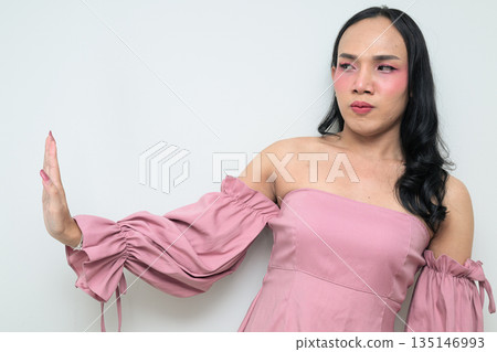 Portrait of a young Thai transgender person against white background with STOP hand gesture Portrait of a young Thai transgender person against white background with STOP hand gesture 135146993