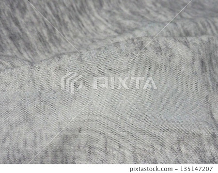 A close-up photo of fabric that is worn out and about to develop holes 135147207