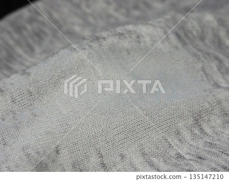 A close-up photo of the fabric that looks worn and likely to develop holes 135147210