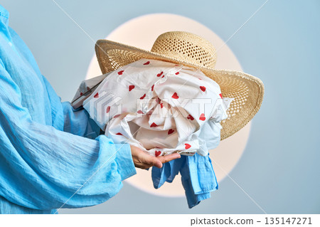 Person carrying laundry and straw hat with heart pattern Person carrying laundry and straw hat with heart pattern 135147271