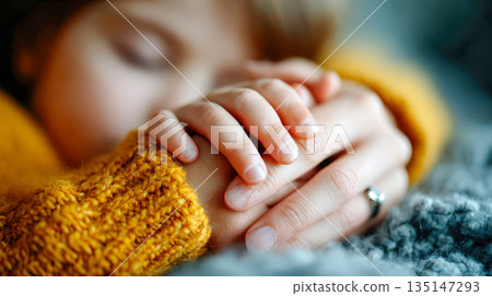 Tender close-up of a sleeping child holding hands with a parent, symbolizing comfort, trust, and family care 135147293