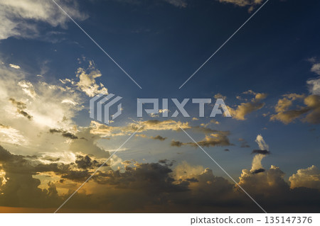 Beautiful sunset sky scenery. Bright colorful orange and yellow clouds on horizon 135147376