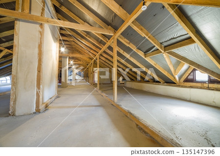 Attic of a building with wooden beams of a roof structure. 135147396
