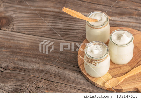 Lactose free yogurt in glass jars on wooden board with copy space, healthy dairy alternative concept 135147513