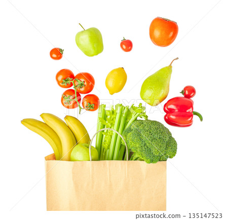 Fresh fruits and vegetables flying above paper grocery bag isolated on white background, healthy food and shopping concept 135147523