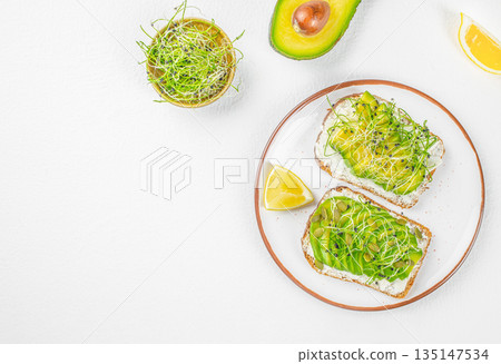 Healthy avocado toast with microgreens on white background and copy space Healthy avocado toast with microgreens on white background and copy space 135147534