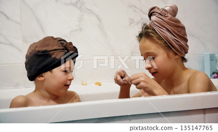 Two children playing with bath foam together at home during evening routine 135147765
