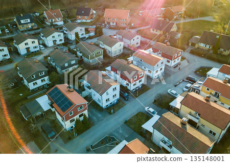 Aerial view of residential houses with red roofs and streets with parked cars in rural town area. Quiet suburbs of a modern european city. Aerial view of residential houses with red roofs and streets with parked cars in rural town area. Quiet suburbs of a modern european city. 135148001