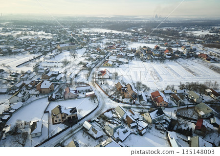 Aerial view of private homes with snow covered roofs in rural suburbs town area in cold winter 135148003