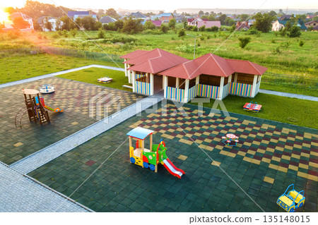 Aerial view of new alcove in kindergarten play yard with red tiled roof for outdoor children activities. 135148015