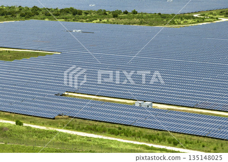 Aerial view of large sustainable electrical power plant with rows of solar photovoltaic panels for producing clean electric energy. Concept of renewable electricity with zero emission 135148025