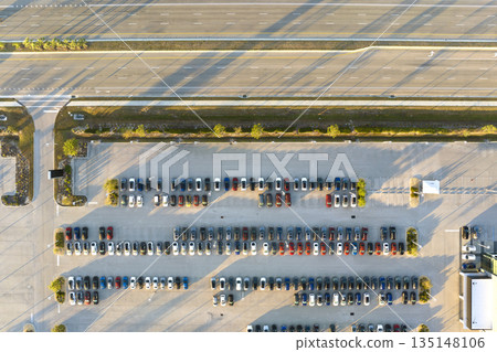Aerial view of dealership parking lot with many brand new cars for sale near wide american highway. Development of US automotive industry concept 135148106