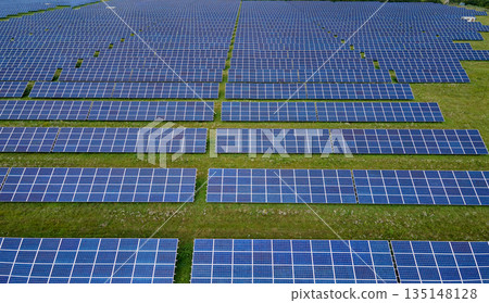 Aerial view of big sustainable electric power plant with many rows of solar photovoltaic panels for producing clean electrical energy. Renewable electricity with zero emission concept Aerial view of big sustainable electric power plant with many rows of solar photovoltaic panels for producing clean electrical energy. Renewable electricity with zero emission concept 135148128