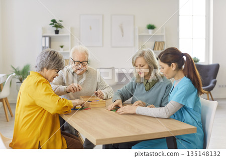 Happy Nurse Playing Board Game With Elderly Patients At Nursing Home 135148132