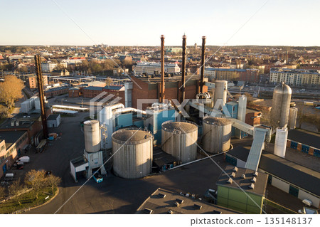 Aerial view of big fuel reservoirs in petroleum industrial zone and metal exhaust pipes of oil refinery factory. 135148137