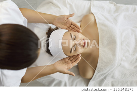 Spa therapist massaging face of woman, facial treatment and relaxation therapy Spa therapist massaging face of woman, facial treatment and relaxation therapy 135148175