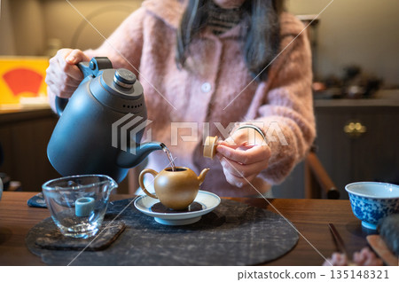 Pouring Flavored Tea From Modern Teapot Into Traditional Cups Pouring Flavored Tea From Modern Teapot Into Traditional Cups 135148321