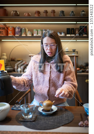 Woman Arranging Teacups On A Beautifully Set Tea Table Woman Arranging Teacups On A Beautifully Set Tea Table 135148322