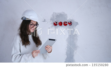 Female engineer wearing helmet and using tablet during construction inspecting electrical system Female engineer wearing helmet and using tablet during construction inspecting electrical system 135150280