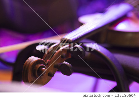 A violin lies on a chair on stage before a concert A violin lies on a chair on stage before a concert 135150604