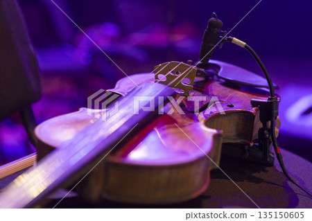 A violin lies on a chair on stage before a concert 135150605