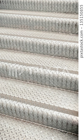 Close-up of industrial metal stairs with diamond plate anti-slip pattern in a modern urban setting Close-up of industrial metal stairs with diamond plate anti-slip pattern in a modern urban setting 135150855