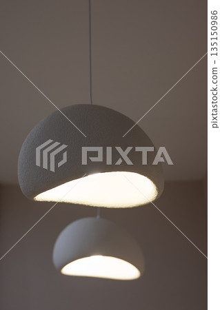 Two modern pendant lamps illuminating a room 135150986