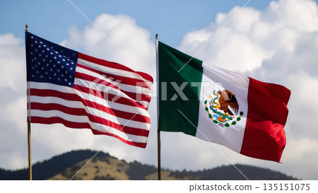 american and mexican flags waving against fluffy white clouds and distant mountain peaks 135151075