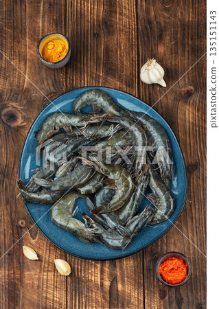 Whole raw langoustines on rustic wooden table. 135151143