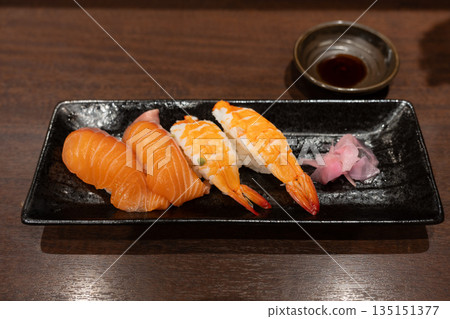 Salmon and shrimp nigiri with pickled ginger and soy sauce on black plate Salmon and shrimp nigiri with pickled ginger and soy sauce on black plate 135151377