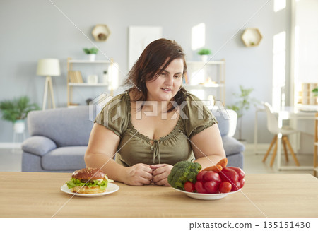 Overweight woman choosing between junk and healthy food Overweight woman choosing between junk and healthy food 135151430