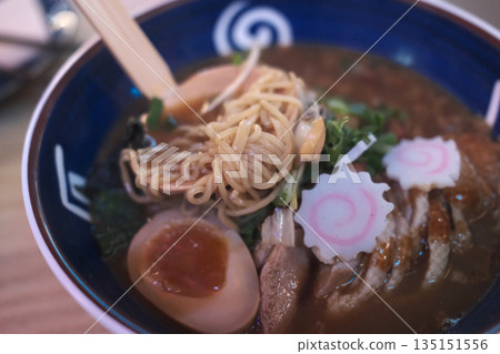 A delicious bowl of traditional Japanese ramen with pork, egg, noodles, and flavorful broth. 135151556