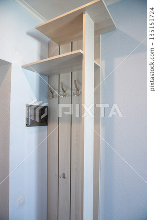 Minimal hallway wardrobe with wooden coat hooks 135151724