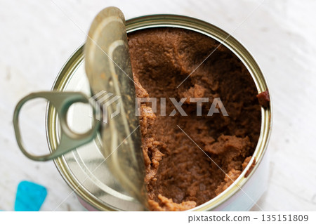 Close photographic shot capturing texture of preserved cooked meat in metal tin can 135151809