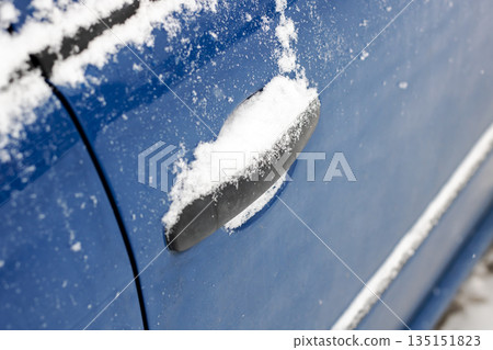 Closeup image of car door handle covered in snow with icy edges and textured surface Closeup image of car door handle covered in snow with icy edges and textured surface 135151823