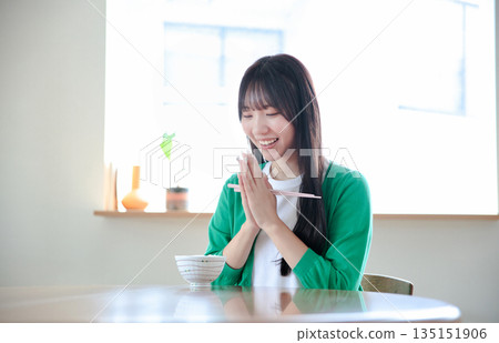 A young woman eating rice A young woman eating rice 135151906
