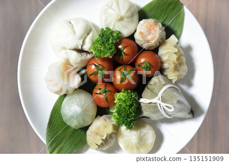 Dim sum and cherry tomatoes served overlooking the plate Dim sum and cherry tomatoes served overlooking the plate 135151909