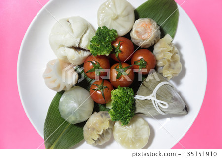 Dim sum and cherry tomatoes served overlooking the plate Dim sum and cherry tomatoes served overlooking the plate 135151910
