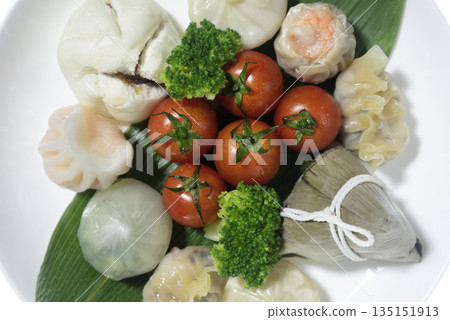 點心和櫻桃番茄擺放在盤子上方。 點心和櫻桃番茄擺放在盤子上方。 135151913